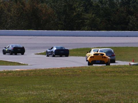 2001 Mercury Grand Marquis - Multiple sports cars compete on a race track during a sunny day.