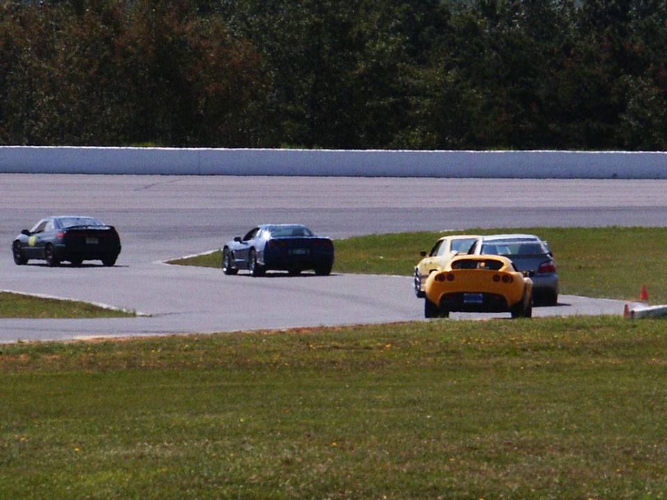Yellow sports car on race track with other cars