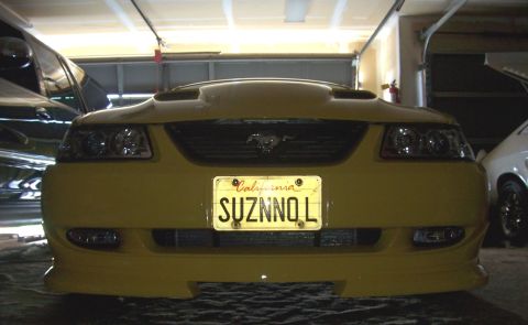 2002 Ford Mustang - Front view of a yellow 2002 Ford Mustang, a California license plate and a prominent hood scoop.