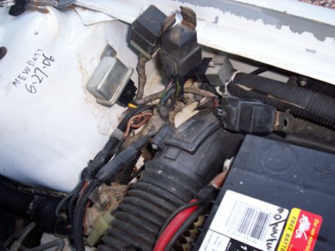 1990 Dodge Shadow - Close-up of the engine compartment wiring and battery of a 1990 Dodge Shadow, with a handwritten note indicating a new battery was installe…