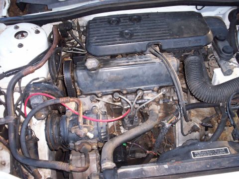 1990 Dodge Shadow - Engine bay details, including engine components and hoses. Watermark present.
