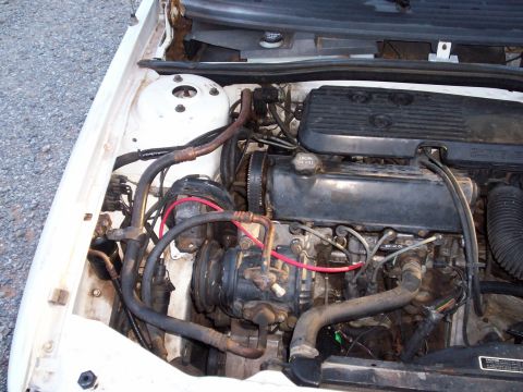 1990 Dodge Shadow - Close-up view of the engine compartment, showing various mechanical parts and wiring.