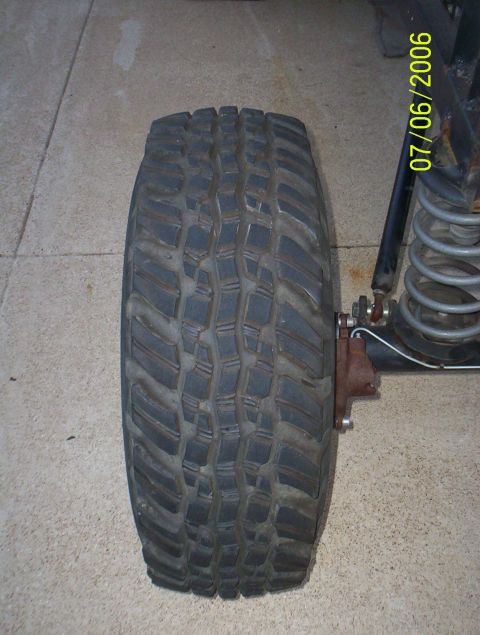 1983 Ford Bronco - A close-up view of an off-road tire and part of the suspension system, with a date stamp in the corner.