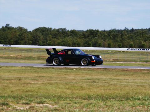 2001 Mercury Grand Marquis - A black racing car with a prominent rear spoiler and the number 23 is seen on a race track.