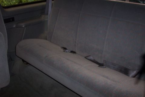 1995 Ford Bronco - The rear seat of a vehicle is shown, with seatbelts visible.