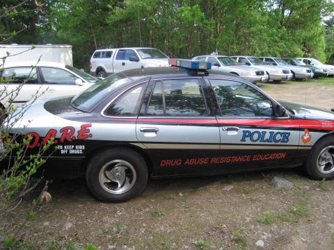 1991 Ford LTD Crown Victoria - Side view of a 1991 Ford Crown Victoria LTD police car marked with D.A.R.E. and "POLICE" graphics.