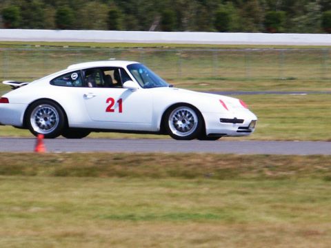 2001 Mercury Grand Marquis - White Porsche 911 with racing number 21 on the door is seen on a race track.