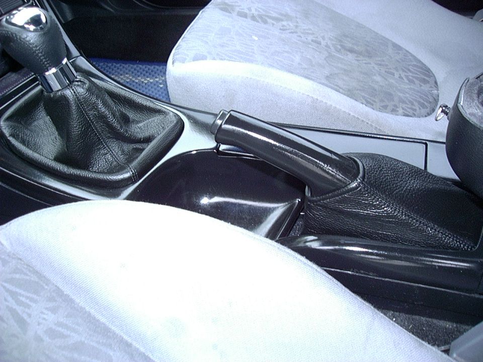 Car interior showing gear shift, handbrake, and part of the passenger seat
