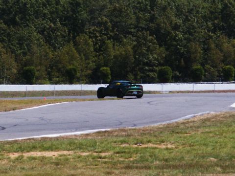 2001 Mercury Grand Marquis - A green sports car navigates a turn on a race track during a sunny day.