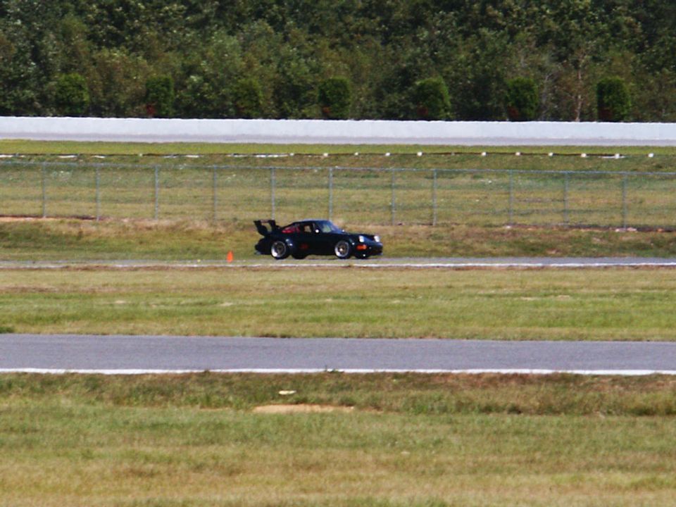 Black Porsche 911 Turbo on a race track, side view