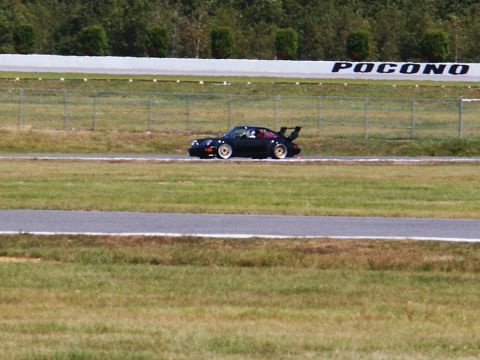 2001 Mercury Grand Marquis - A black Porsche 911 is seen on the Pocono race track, with a prominent rear spoiler and gold wheels.