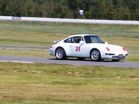 2001 Mercury Grand Marquis - A white Porsche 911 with racing number 21 is seen on a race track.