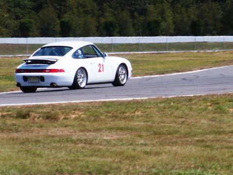 2001 Mercury Grand Marquis - White Porsche 911 with racing number 21 on the door drives on a race track.