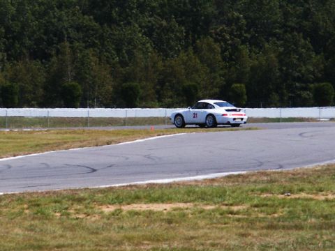 2001 Mercury Grand Marquis - A white Porsche 911 is seen on a race track, with a number 21 visible on its side.