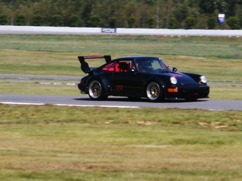 2001 Mercury Grand Marquis - A black Porsche 911 race car with number 23 on its side is seen on a race track.