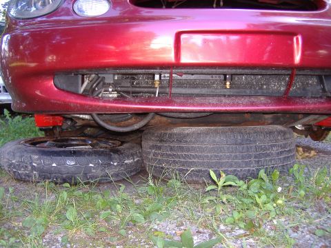 1998 Ford Taurus - Front view of a red 1998 Ford Taurus with spare tires placed underneath.