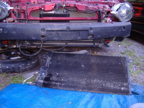 1998 Ford Taurus - The front of a car is shown with the radiator removed, revealing the engine bay and a spare tire.