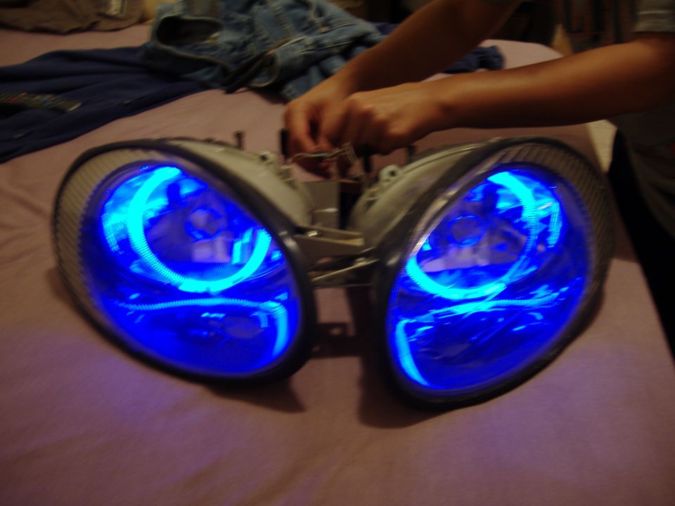 Pair of aftermarket headlights with blue halo lights, possibly for a car