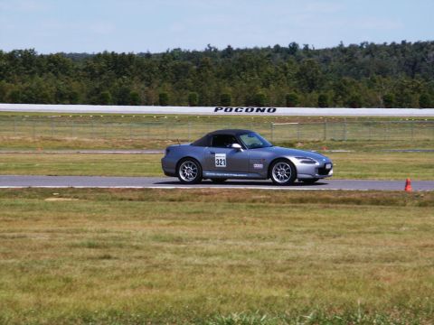 2001 Mercury Grand Marquis - A silver convertible sports car with racing decals and the number 321 on the door drives on the Pocono Raceway track.
