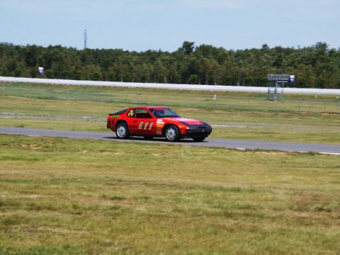 2001 Mercury Grand Marquis - A red race car with the number 611 is seen on a track during a race event.
