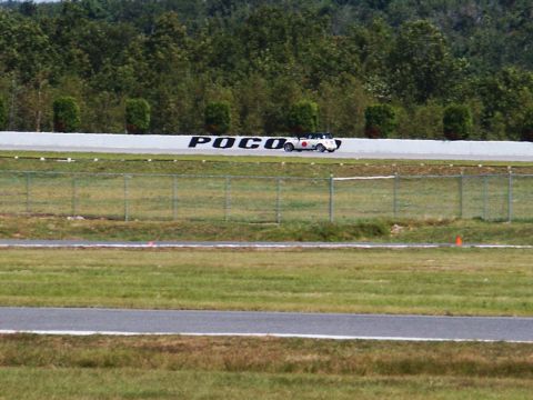 2001 Mercury Grand Marquis - A white convertible is seen on a race track with trees in the background.