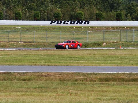 2001 Mercury Grand Marquis - A red race car numbered 611 drives on a track at Pocono Raceway.