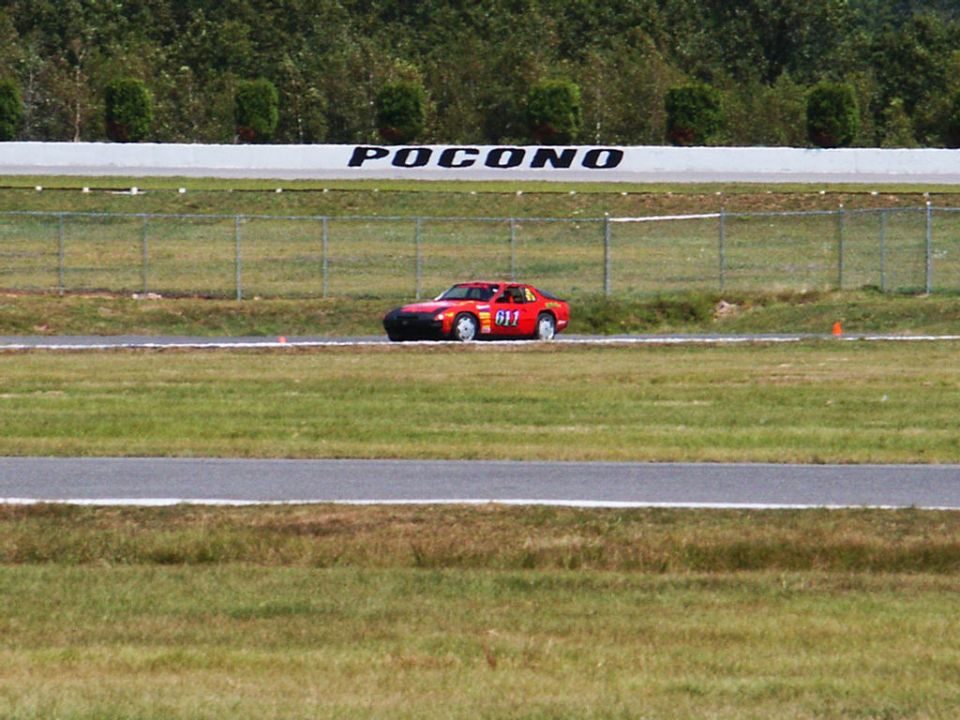 Red race car with number 611 on a track with 'POCONO' visible on the wall