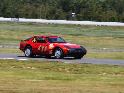 2001 Mercury Grand Marquis - A red race car with the number 611 is seen on a race track during a sunny day.