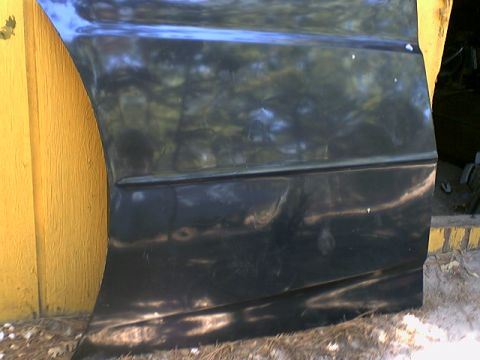 1973 Ford Ranchero - A black car door, possibly from a Ford Ranchero, is shown leaning against a yellow wall.