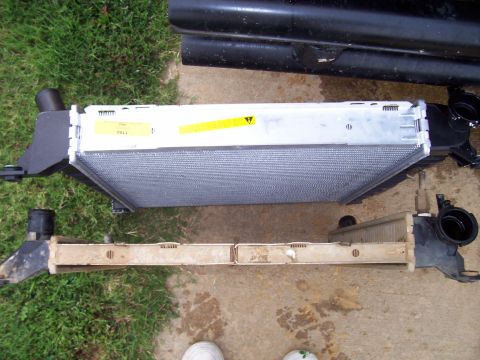 1989 Ford Bronco II - A new radiator sits above an older, removed radiator, likely for comparison or replacement.