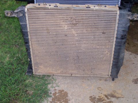 1989 Ford Bronco II - A used car radiator is shown removed from a vehicle, with visible dirt and debris on its fins.