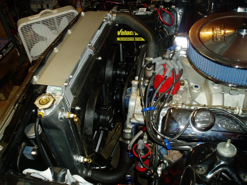 Engine bay with a large aluminum radiator, blue air filter, and red distributor cap