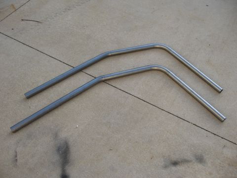1977 Ford F-150 - Two bent metal tubes are shown on a concrete surface.
