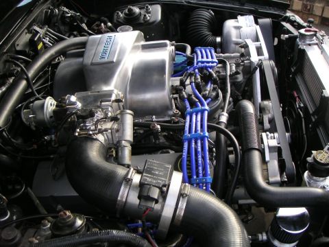 1969 Ford Mustang - Close-up view of a modified engine bay a prominent Vortech supercharger and custom blue ignition wires.