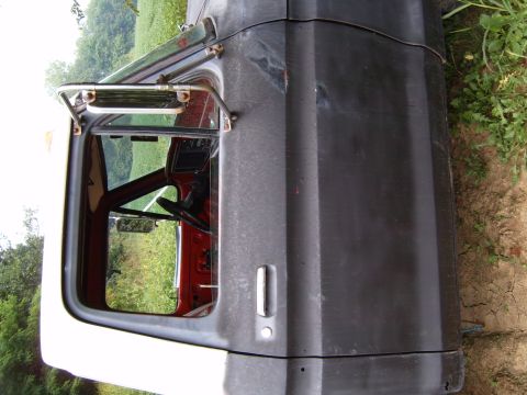1993 Ford Bronco - Side view of a weathered Ford Bronco door and interior, showing the steering wheel and dashboard.