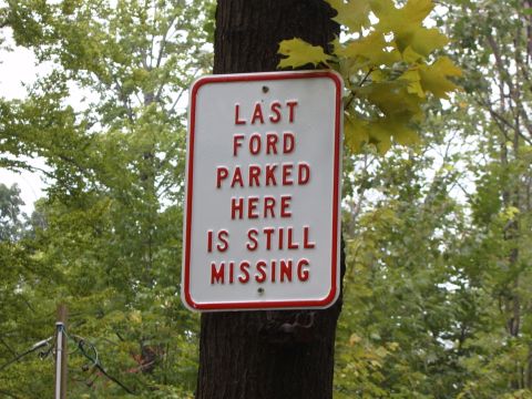 1993 Ford Bronco - A sign attached to a tree in a wooded area indicates a missing Ford vehicle.