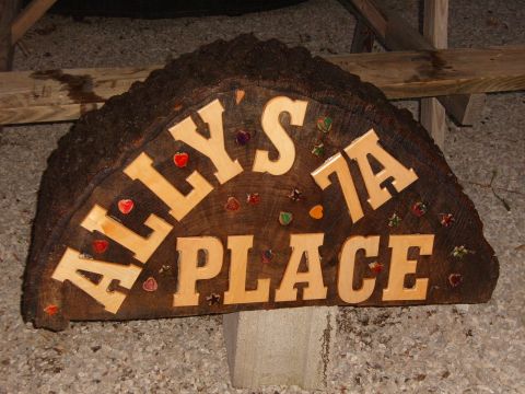 1993 Ford Bronco - A rustic wooden sign with carved lettering and decorative accents is displayed outdoors.