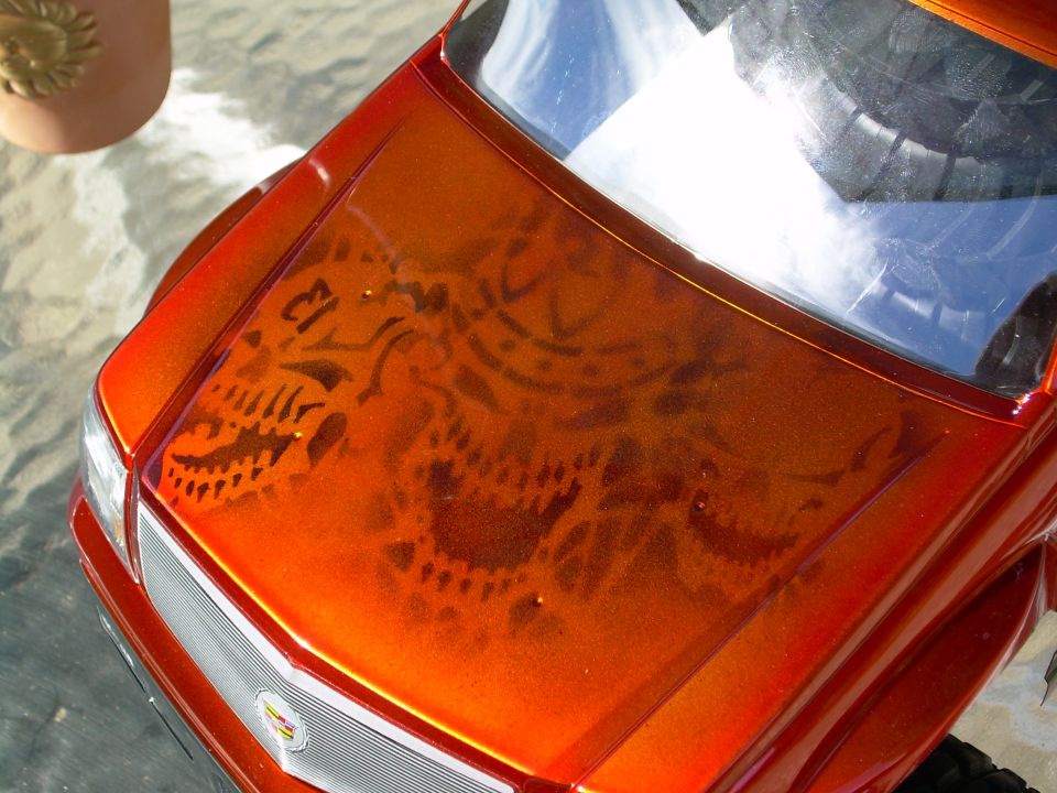 Airbrushed skull graphic on the orange hood of a Cadillac Escalade R/C body