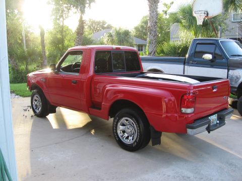 1974 Ford F-100 - Red Ford Ranger pickup truck parked in a driveway with a second truck behind it.