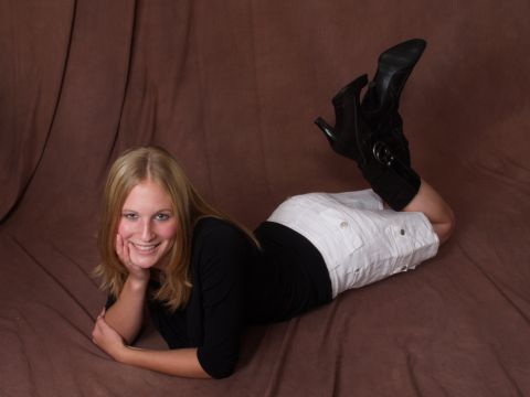 1996 Ford Bronco - Woman in black top and white shorts with black boots lying down on a brown background.