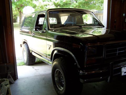 1983 Ford Bronco - This black 1983 Ford Bronco is shown from a three-quarter front view, parked inside a garage.