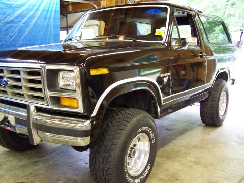 1983 Ford Bronco - Front 3/4 view of a black 1983 Ford Bronco, showing its distinctive body style and chrome accents.