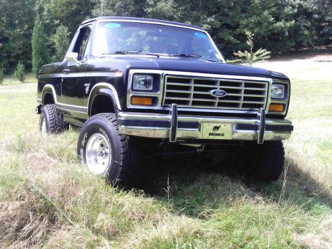 1983 Ford Bronco - This lifted Ford Bronco features a prominent chrome grille and bumper, with the 'Bronco' emblem visible on the front.