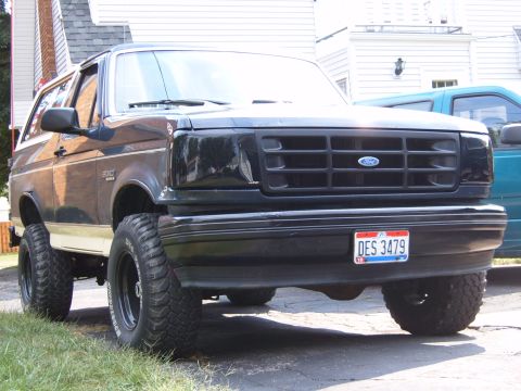 1993 Ford Bronco - Front view of a black 1993 Ford Bronco with aftermarket wheels and tires parked outside.