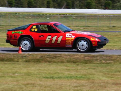 2001 Mercury Grand Marquis - A red race car, number 611, navigates a track with multiple sponsor decals visible on its body.