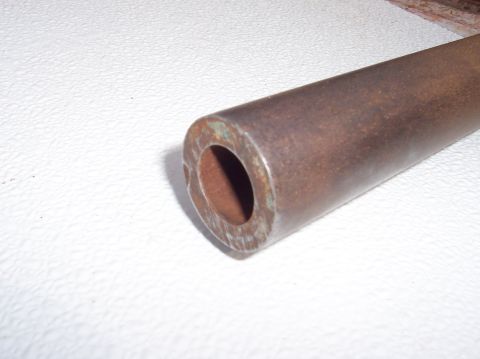 1979 Ford Bronco - A close-up of a corroded metal pipe, showing its hollow interior and textured surface.