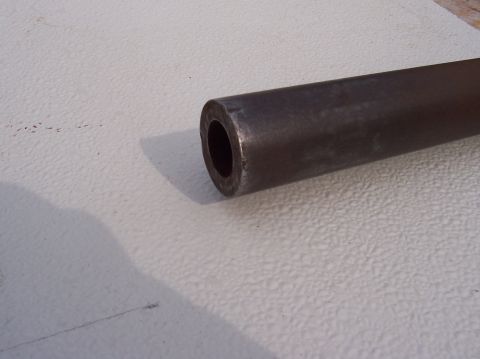 1979 Ford Bronco - A metal tube is shown in close-up, with its hollow end visible against a textured background.