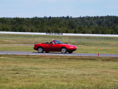 2001 Mercury Grand Marquis - A red convertible drives on a race track with 'POCONO' visible in the background.