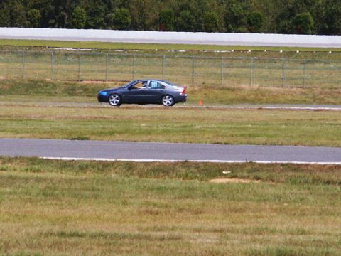 2001 Mercury Grand Marquis - A dark sedan navigates a race track during an event.