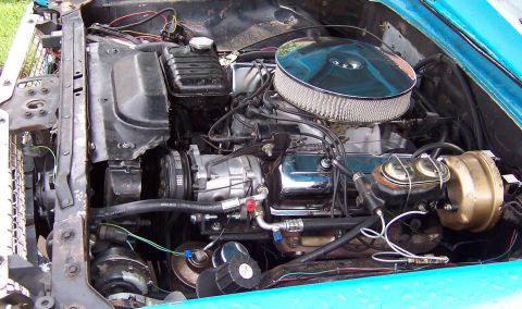 1963 Ford Galaxie - The engine bay of a 1963 Ford Galaxie, a V8 engine with a chrome air cleaner and visible AC components.